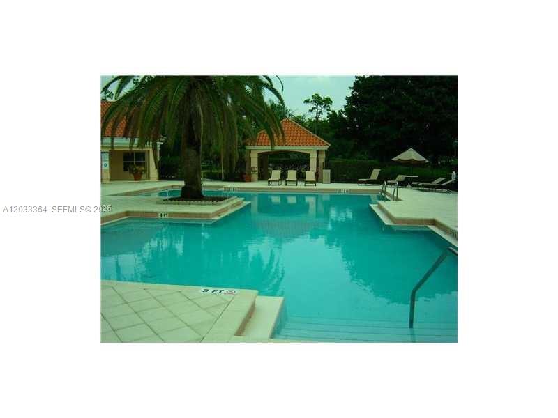 A swimming pool with a palm tree, lounge chairs, and a gazebo in the background — 3350 N Pinewalk Dr N # 1427, Margate FL 33063, MARGATE, FL