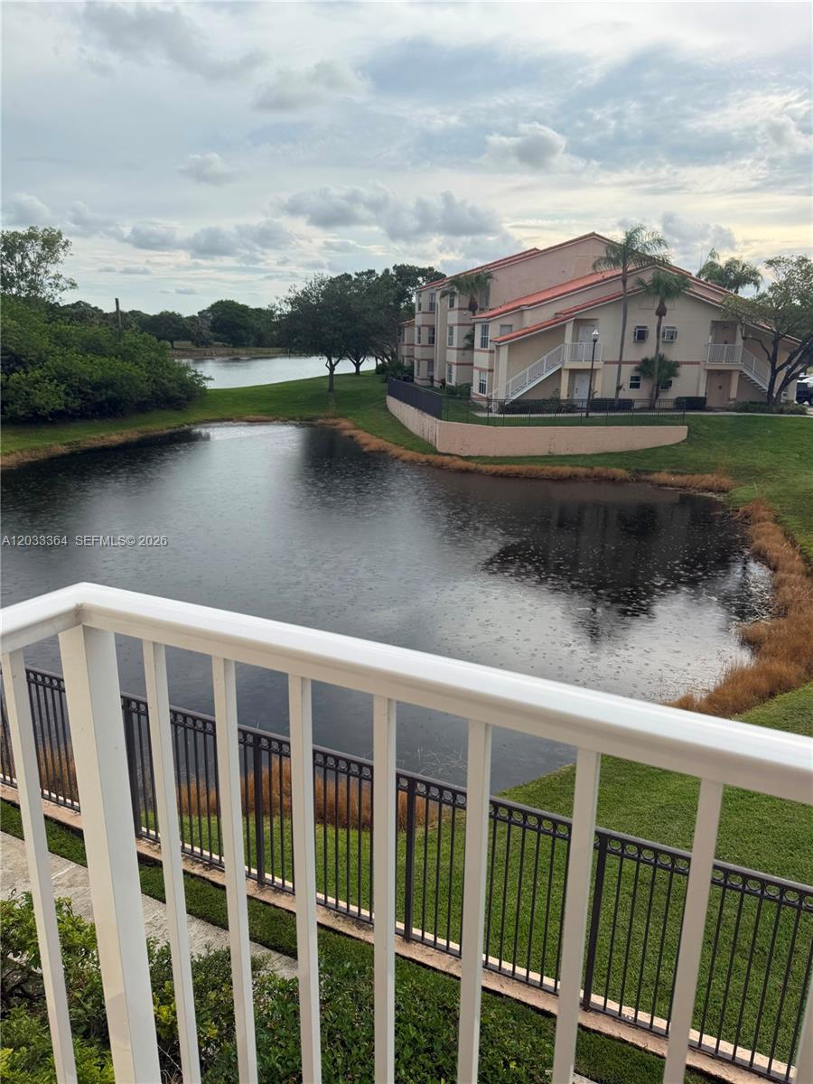 A view from a balcony overlooking a pond and a multi-story apartment building — 3350 N Pinewalk Dr N # 1427, Margate FL 33063, MARGATE, FL