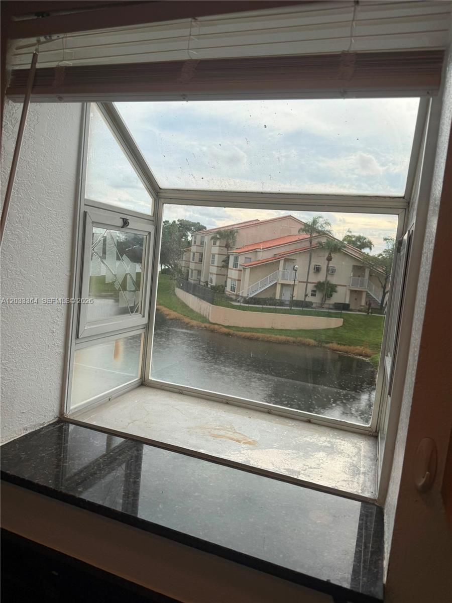 A garden window with a black granite sill overlooks a pond and apartment buildings — 3350 N Pinewalk Dr N # 1427, Margate FL 33063, MARGATE, FL