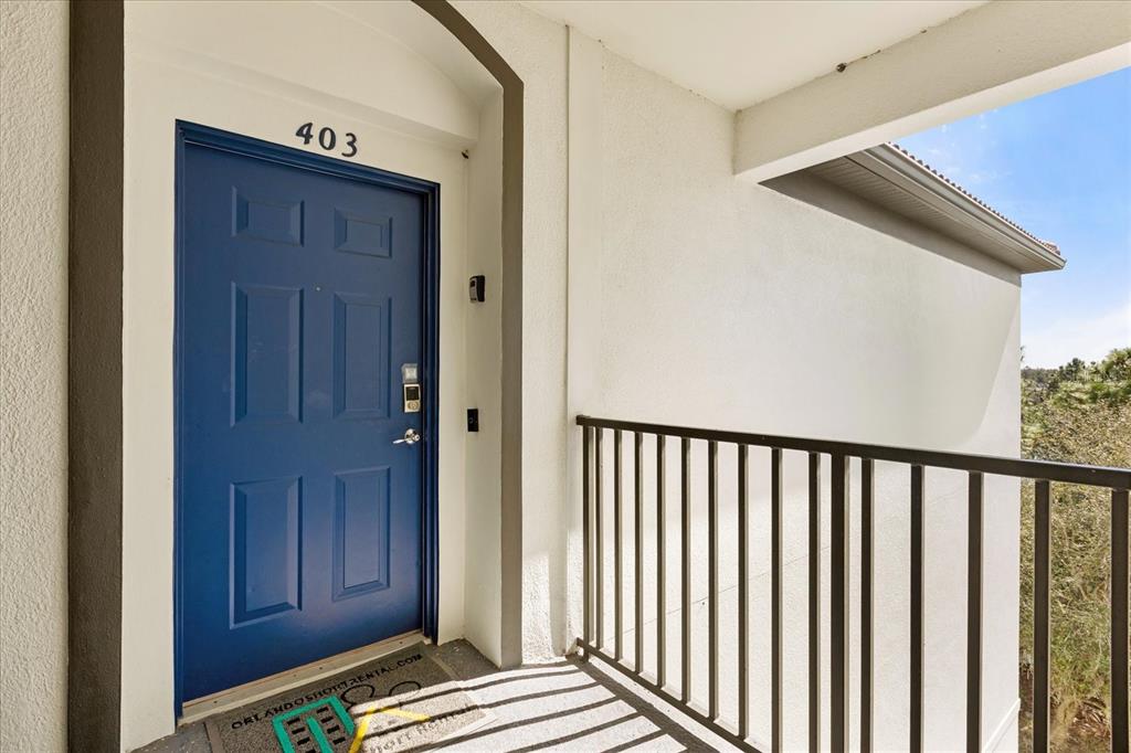 A blue front door with the number 403 is located on an outdoor balcony — 4024 BREAKVIEW DRIVE UNIT 40304, ORLANDO, FL