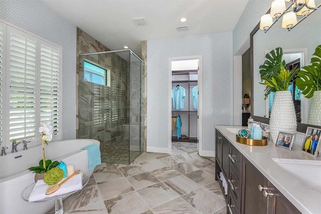 A bedroom features a four-poster bed, two light blue armchairs, and a large window view — 332 BOCELLI DRIVE, NORTH VENICE, FL