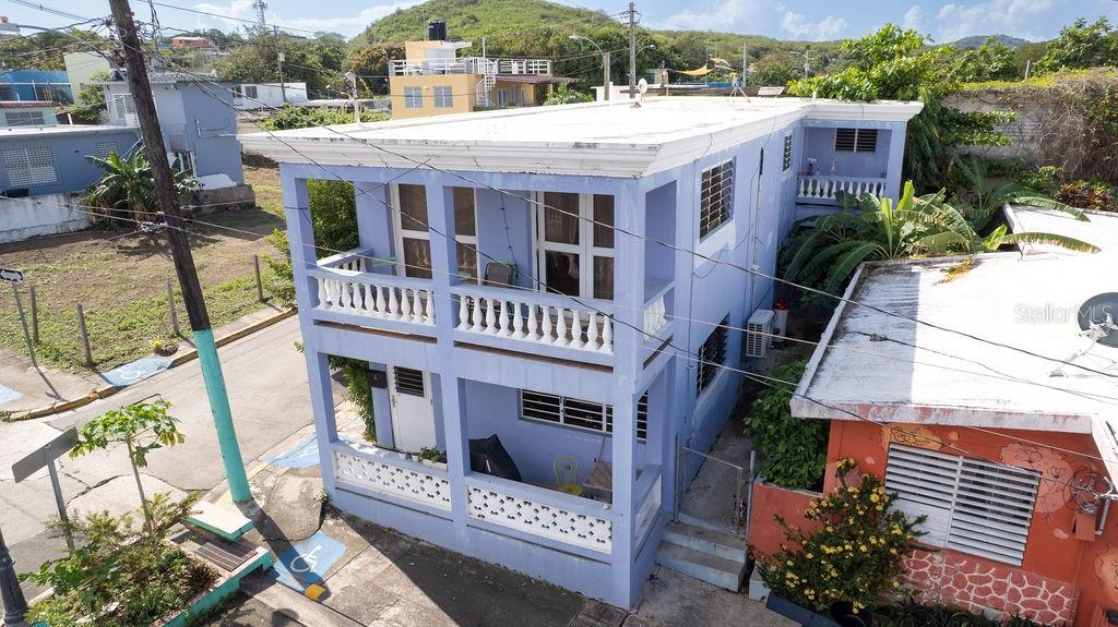 An elevated exterior view of a two-story blue house with balconies and a flat roof — 112 CALLE MUÑOZ RIVERA, VIEQUES, PR