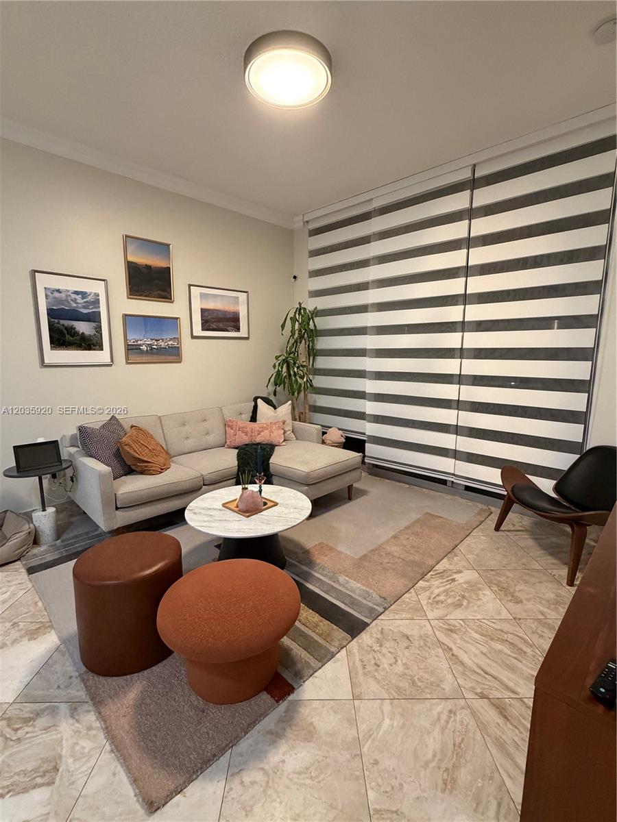 A living room features a light gray sectional sofa, a marble coffee table, and striped blinds — 3470 E Coast Ave # H1206, Miami FL 33137, MIAMI, FL