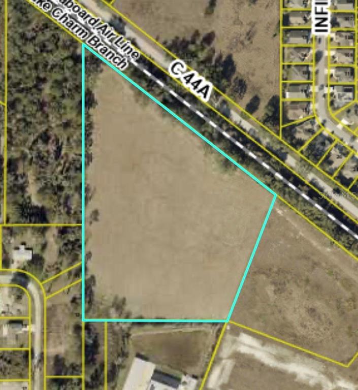 This aerial map shows a vacant, irregularly shaped plot of land outlined in light blue — 0 COUNTY ROAD 44 A, WILDWOOD, FL