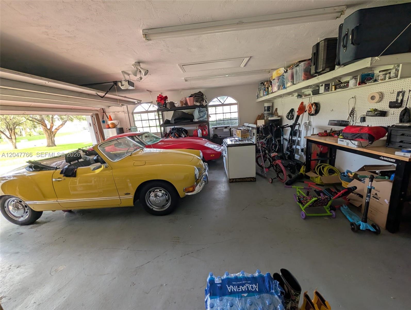 A garage contains two classic cars, a workbench, storage shelving, and various household items — 5131 SW 201st Ter, Southwest Ranches FL 33332, SOUTHWEST RANCHES, FL