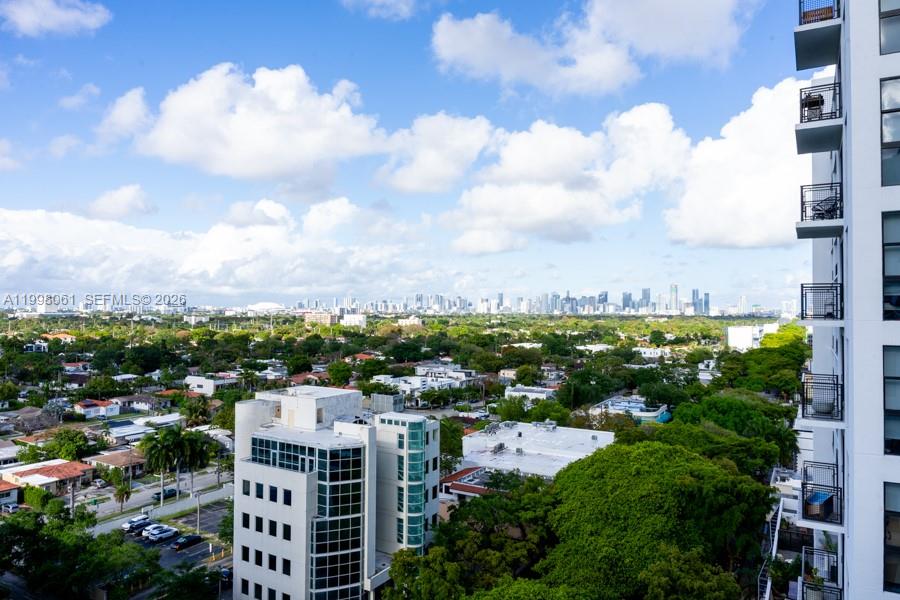 An elevated view shows a city skyline beyond a residential neighborhood and a modern building — 3180 SW 22nd Ter # 1205, Miami FL 33145, MIAMI, FL