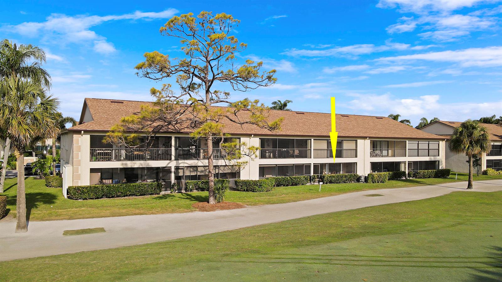 An exterior view of a two-story apartment building with screened balconies overlooking a golf course — 1001 Pinecrest Circle # C, Jupiter FL 33458, JUPITER, FL