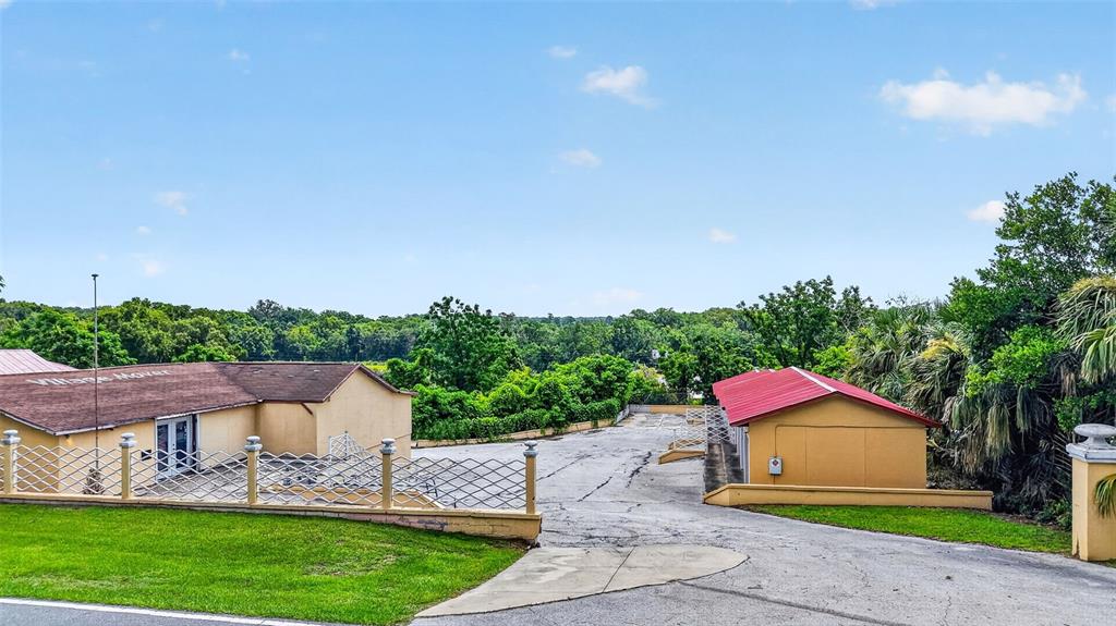 An exterior view shows two tan buildings with red roofs and a paved driveway — 2766 US HIGHWAY 441/27 HIGHWAY, FRUITLAND PARK, FL