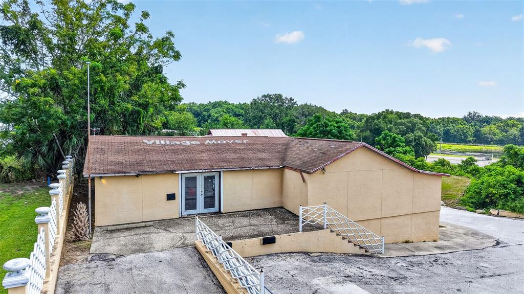 An exterior view of a single-story tan building with a brown shingled roof — 2766 US HIGHWAY 441/27 HIGHWAY, FRUITLAND PARK, FL