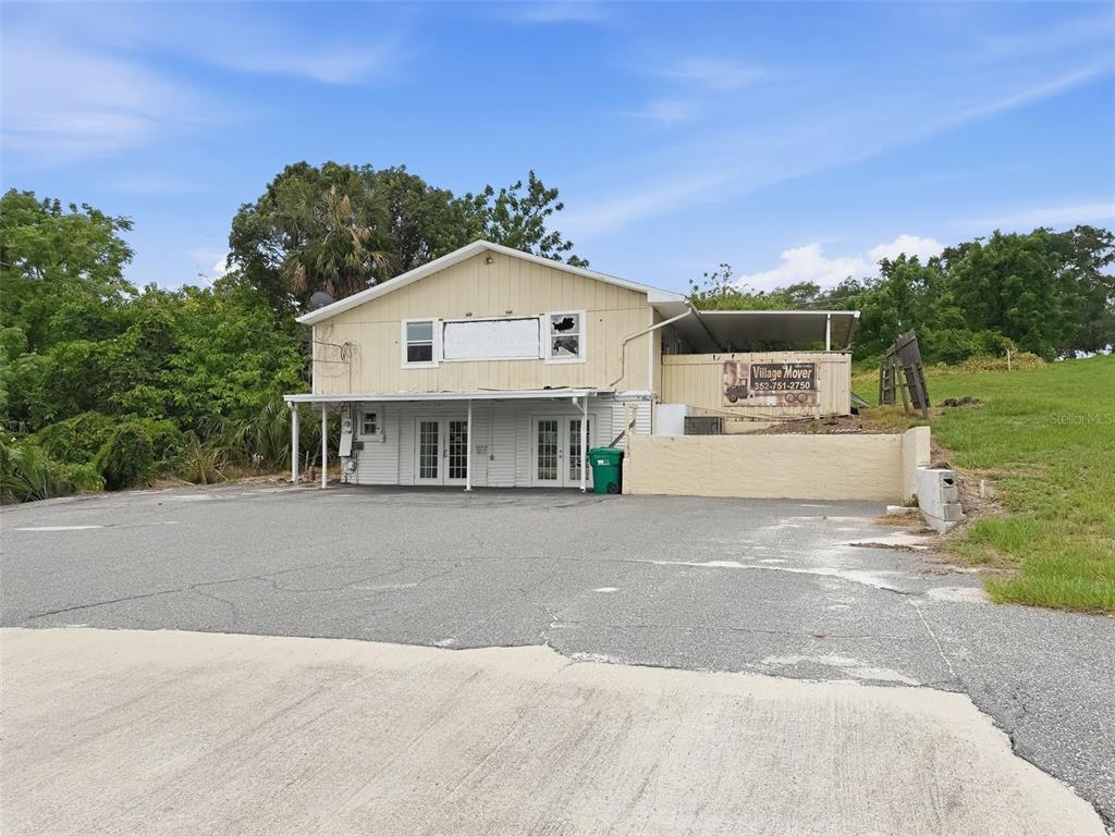 A two-story building with a paved parking lot and a Village Mover sign — 2766 US HIGHWAY 441/27 HIGHWAY, FRUITLAND PARK, FL