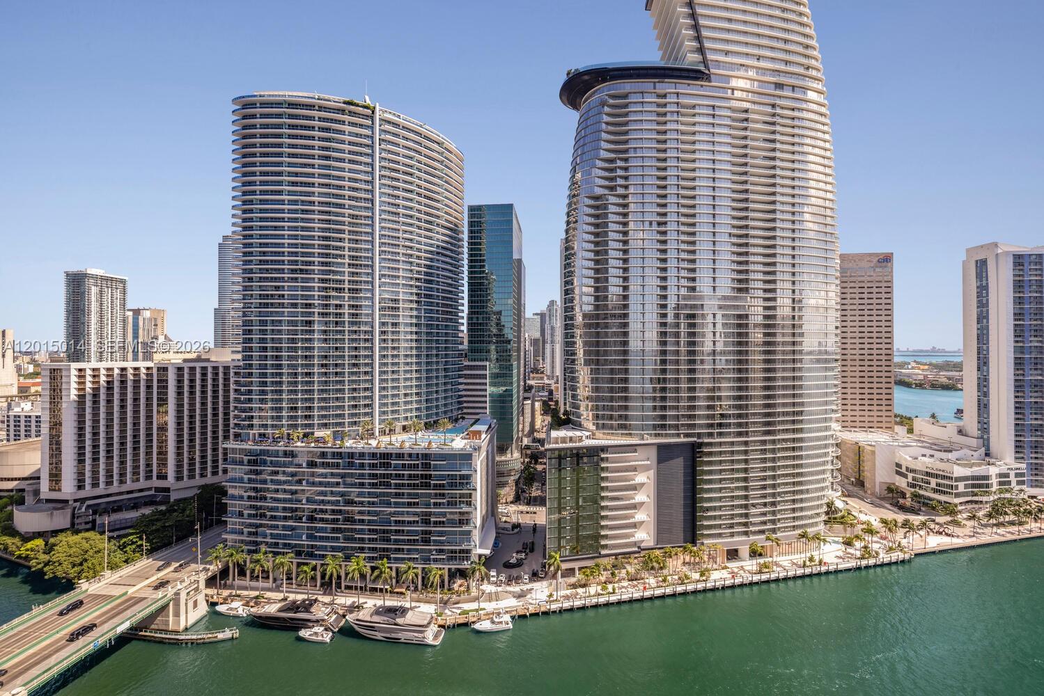 An aerial view of modern high-rise buildings along a waterfront with boats docked below — 475 Brickell Ave # 2610, Miami FL 33131, MIAMI, FL