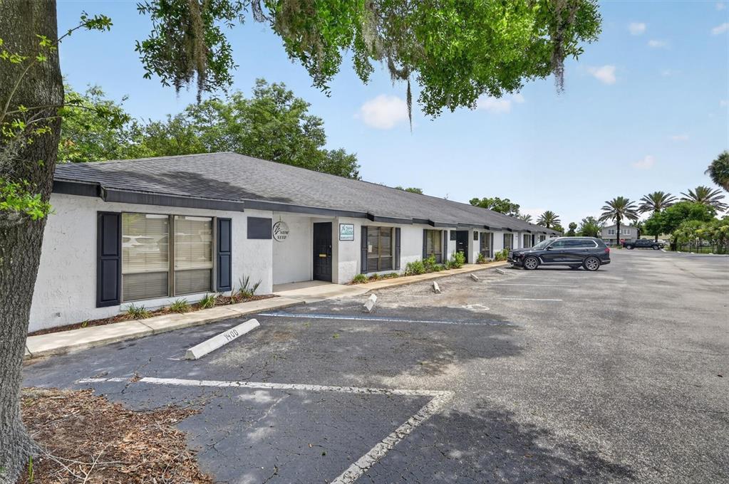 A single-story commercial building with a parking lot and a dark-colored roof — 7 W MAIN STREET UNIT 12-14, APOPKA, FL