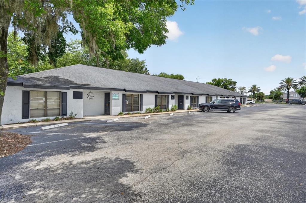 A single-story commercial building with a parking lot and mature trees in front — 7 W MAIN STREET UNIT 12-14, APOPKA, FL
