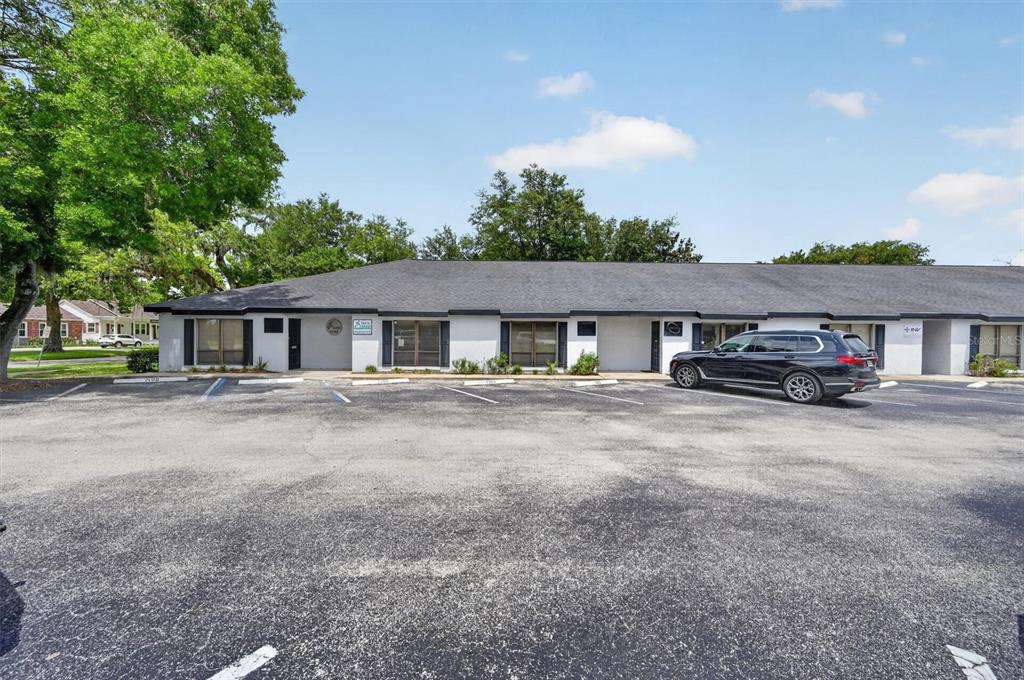 A single-story commercial building with a parking lot in front under a blue sky — 7 W MAIN STREET UNIT 12-14, APOPKA, FL