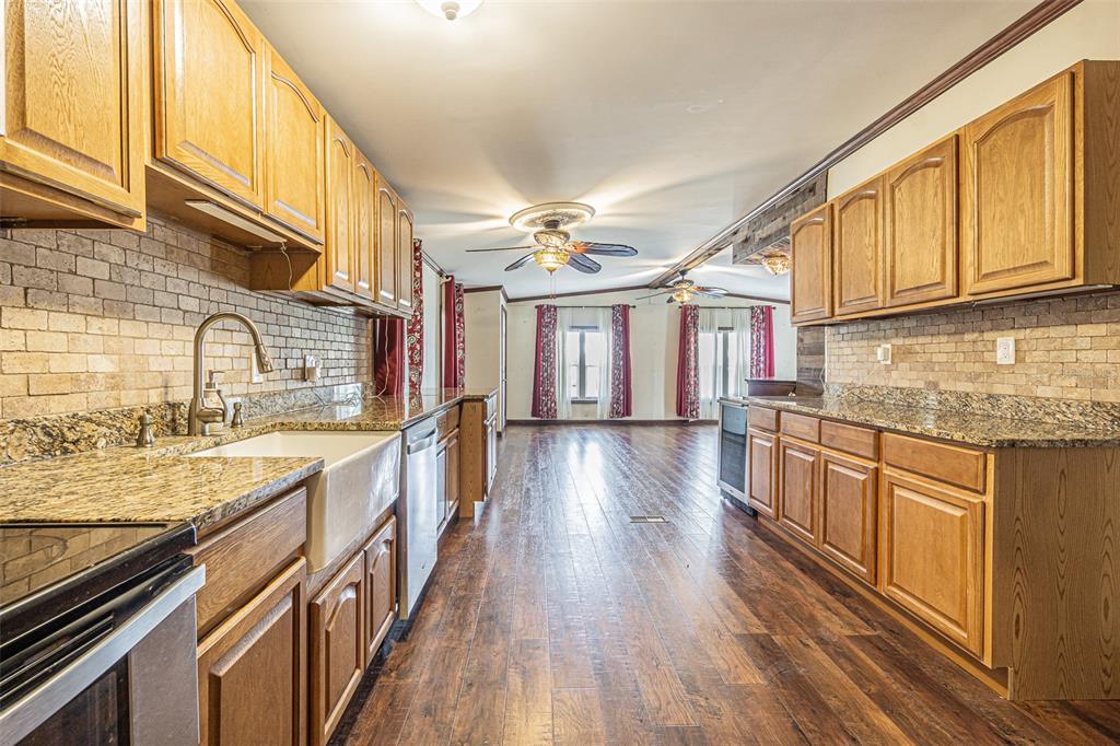 A kitchen with wood cabinets, granite countertops, a farmhouse sink, and wood-look flooring — 34445 COUNTRYSIDE DRIVE, WESLEY CHAPEL, FL