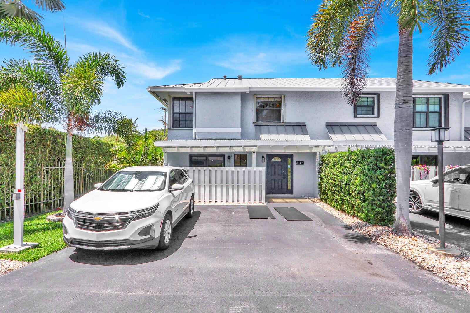 A two-story gray townhouse with a white picket fence and a parked white SUV — 611 NE 12th Terrace # 1, Boynton Beach FL 33435, BOYNTON BEACH, FL