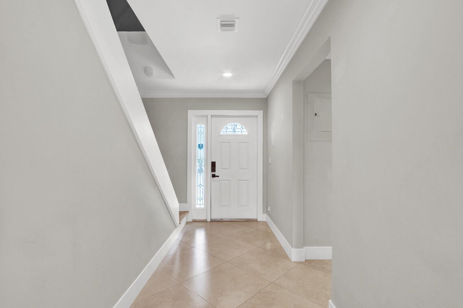 A bright entryway features light tile flooring, gray walls, and a white front door — 611 NE 12th Terrace # 1, Boynton Beach FL 33435, BOYNTON BEACH, FL