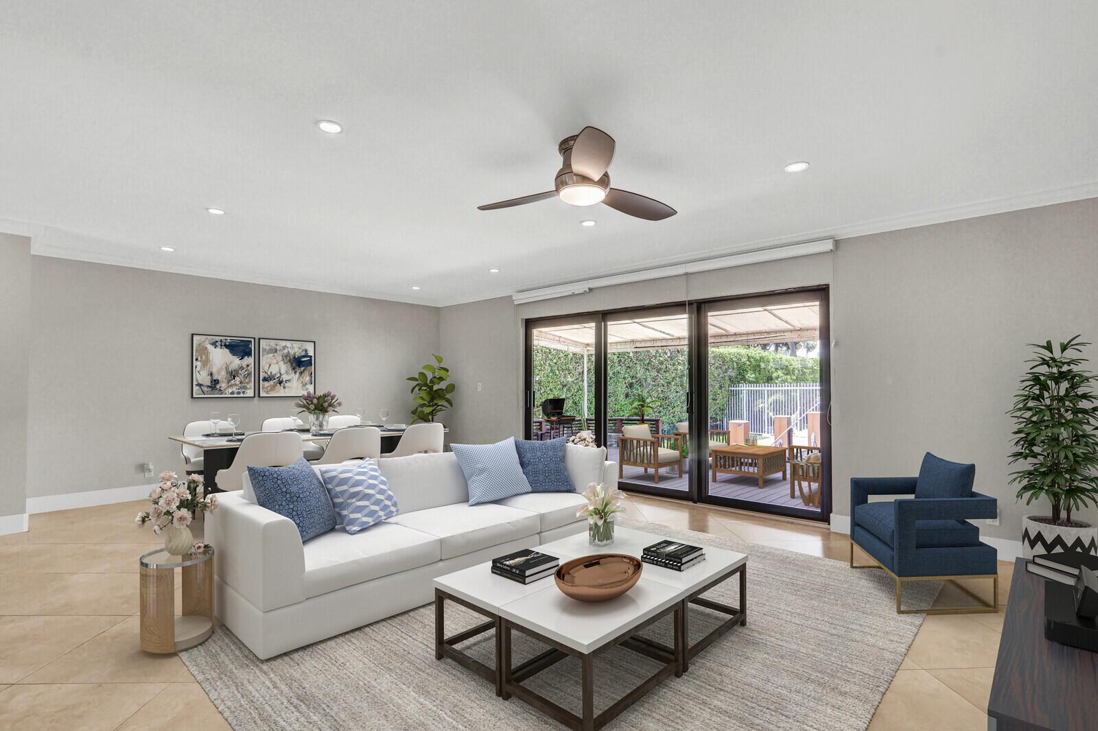 A living room with a white sofa, coffee tables, and sliding doors opening to a patio — 611 NE 12th Terrace # 1, Boynton Beach FL 33435, BOYNTON BEACH, FL