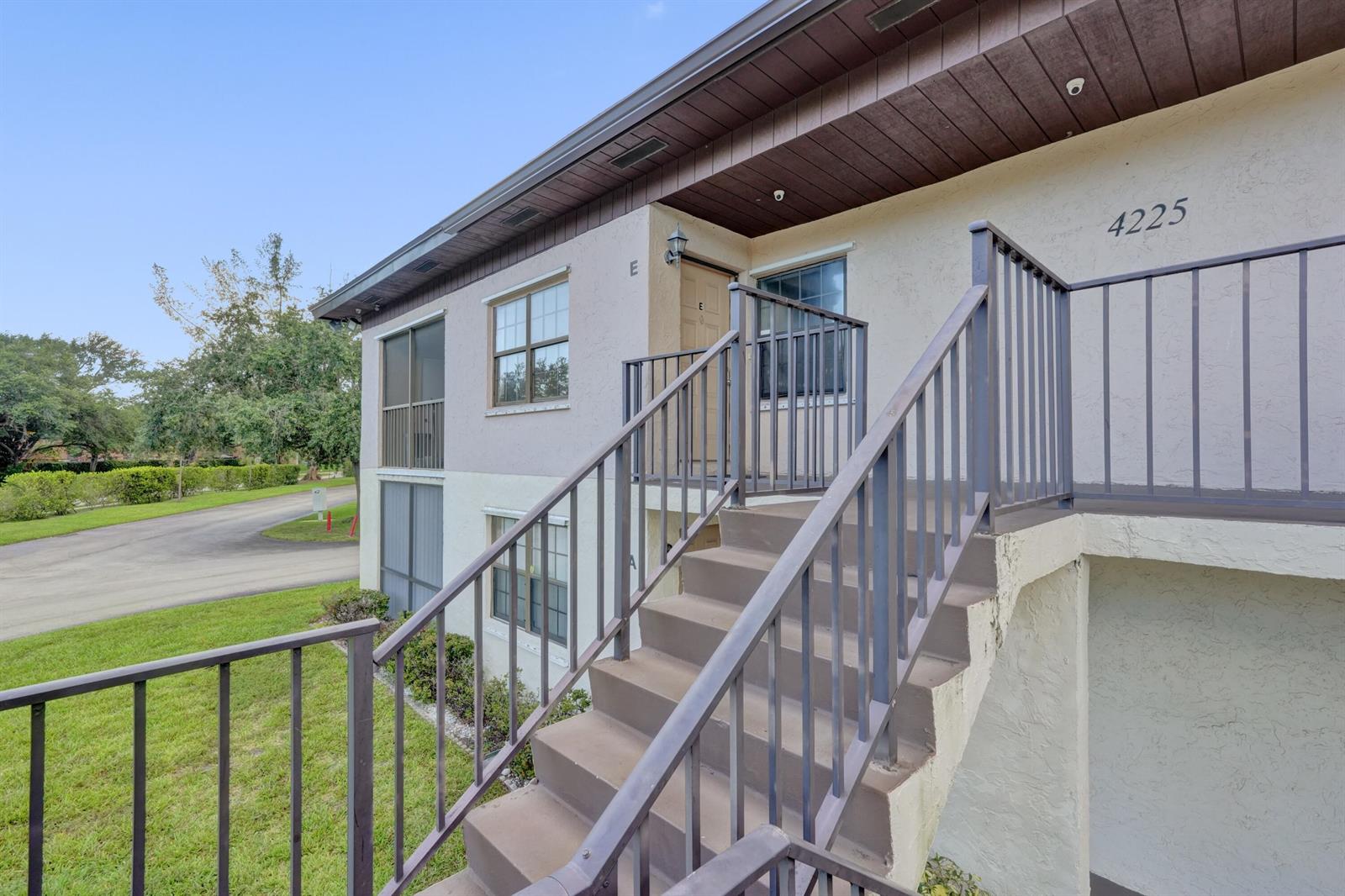 An exterior view of a two-story apartment building with concrete stairs and metal railings — 4225 S 57th Avenue, FL 33463, FL