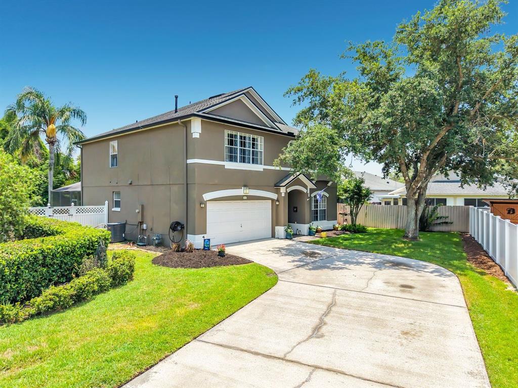 A two-story house with a brown exterior, a white garage door, and a concrete driveway — 14664 SAINT GEORGES HILL DRIVE, ORLANDO, FL