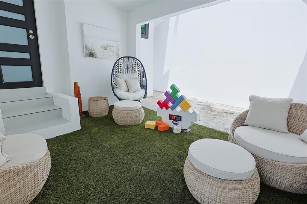 A covered patio features artificial turf, wicker furniture, and a Tetris-themed game set — 1717 CALLE COLON, SANTURCE, PR