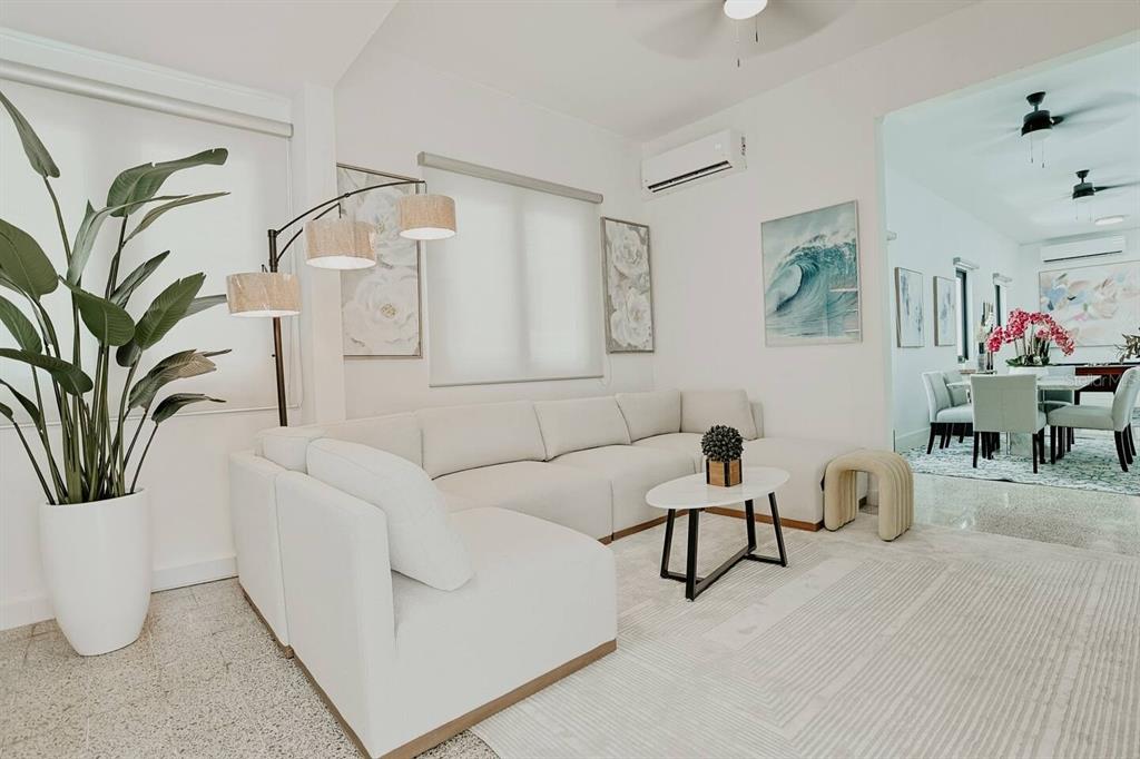 A bright living room features a large white sectional sofa, a coffee table, and decor — 1717 CALLE COLON, SANTURCE, PR
