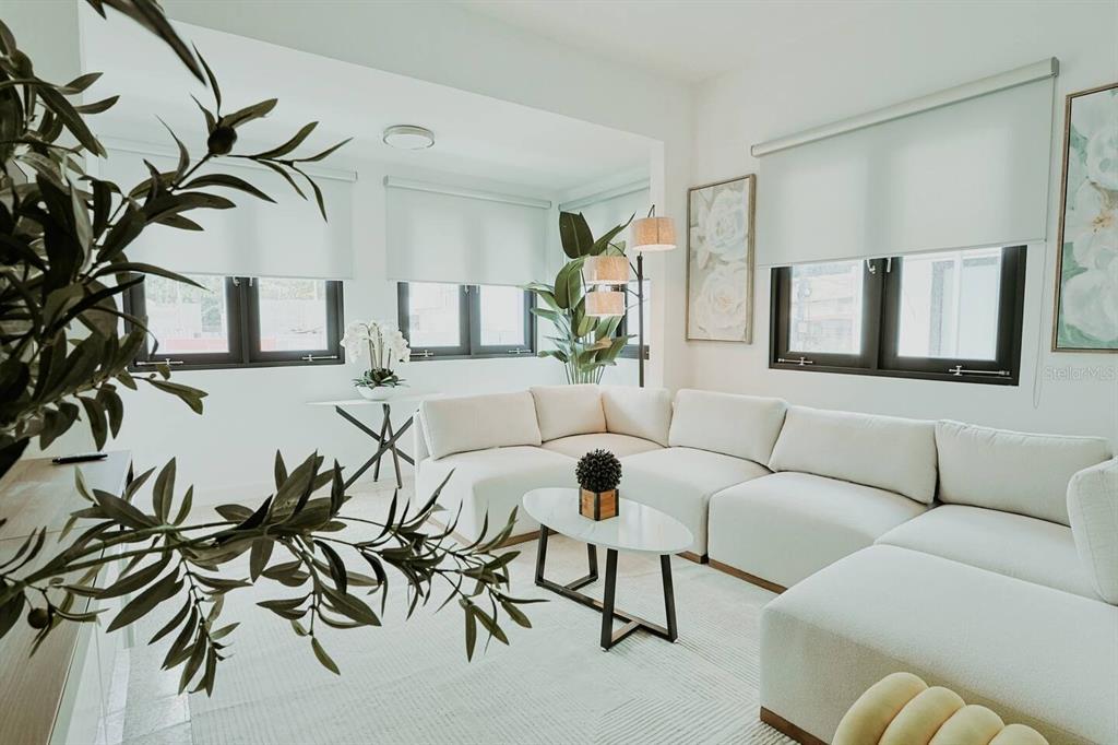 A bright living room features a large white sectional sofa, a coffee table, and windows — 1717 CALLE COLON, SANTURCE, PR