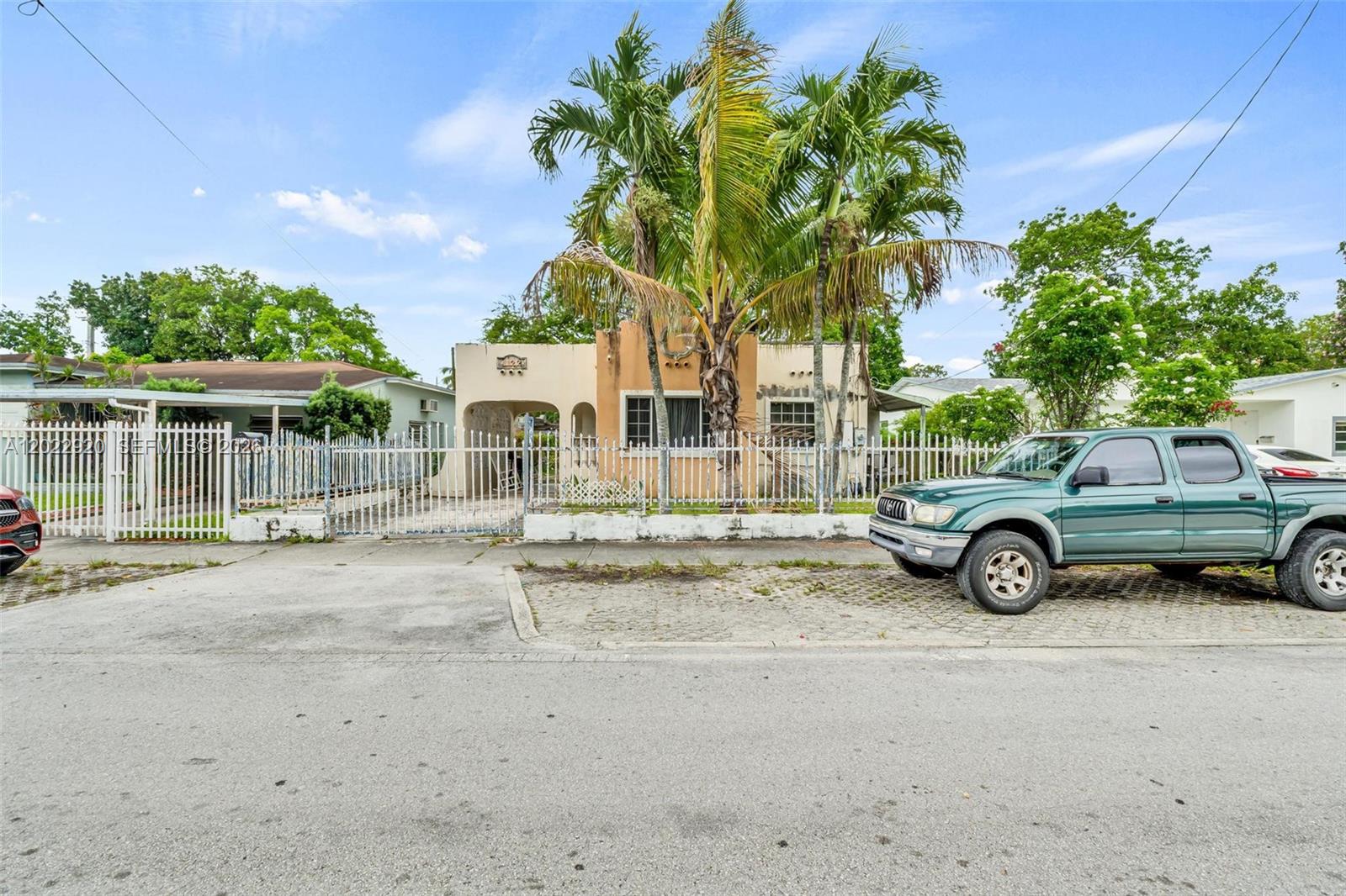 A single-story house with a palm tree and a green pickup truck parked in front — 1122 NW 38th St, Miami FL 33127, MIAMI, FL