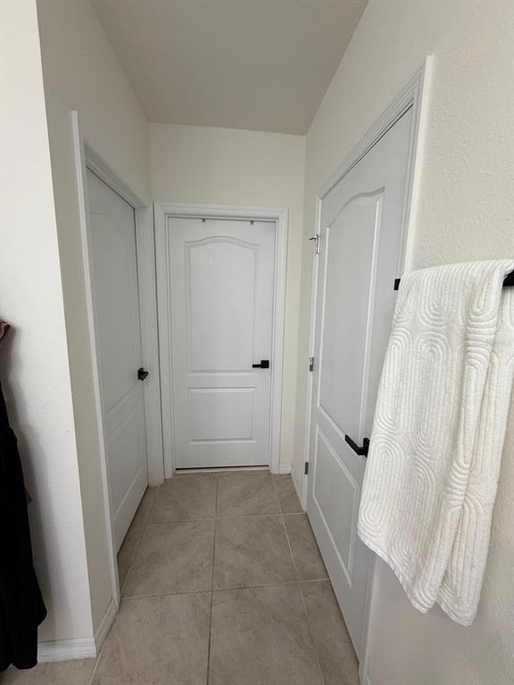 A hallway features three white doors with black hardware and light-colored tile flooring — 5268 MADDIE DRIVE, HAINES CITY, FL