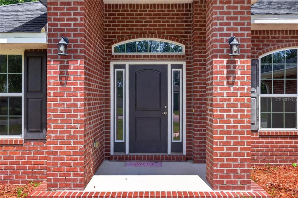 The exterior of a brick house features a front entrance with a dark door — 15 KANE PLACE, PALM COAST, FL