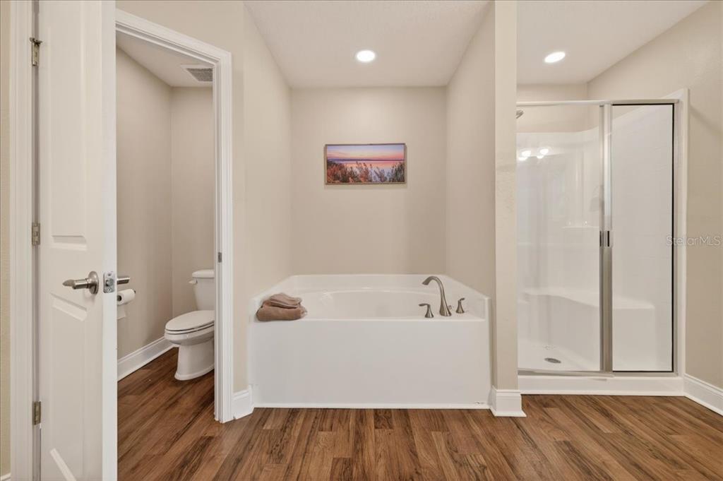 A bathroom featuring a soaking tub, a separate glass-enclosed shower, and a private toilet area — 15 KANE PLACE, PALM COAST, FL