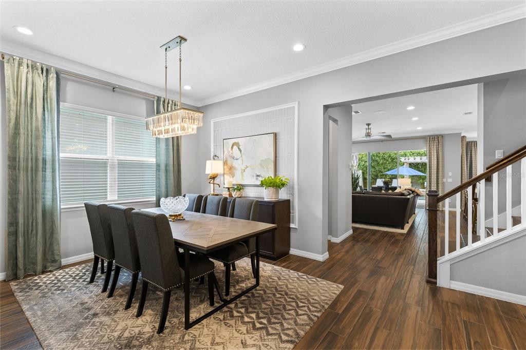 A dining room with a wooden table, gray chairs, a chandelier, and a patterned rug — 1448 LAKE FLORENCE WAY, WINTER PARK, FL