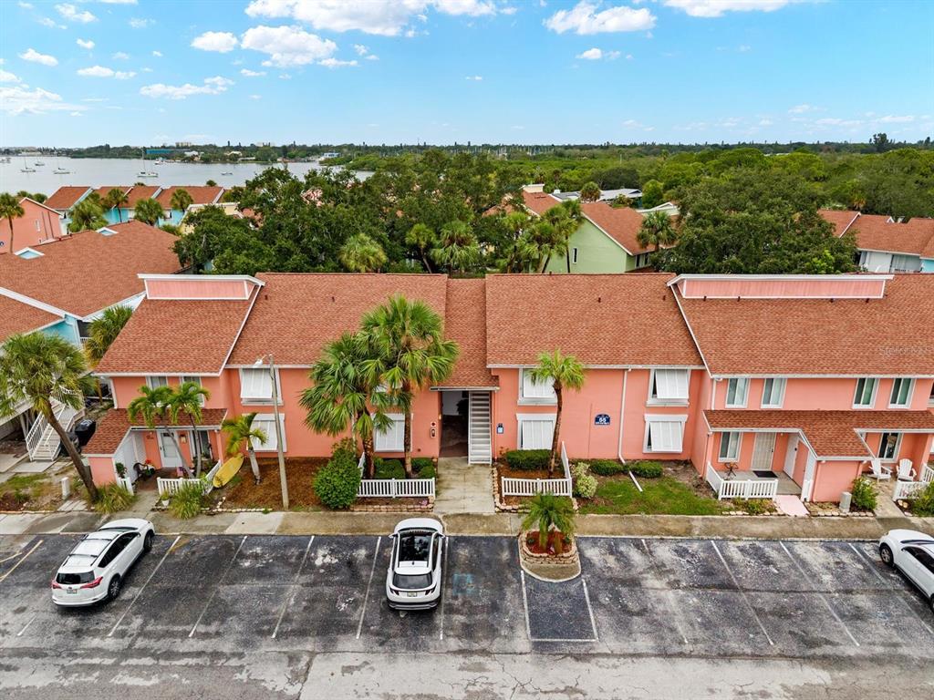 An aerial view of a two-story pink residential building with a parking lot in front — 3675 41ST WAY S UNIT I, ST PETERSBURG, FL