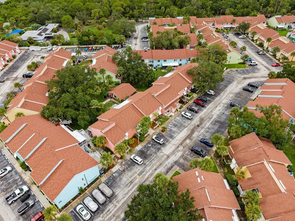 An aerial view shows multiple residential buildings with orange roofs surrounded by parking lots — 3675 41ST WAY S UNIT I, ST PETERSBURG, FL