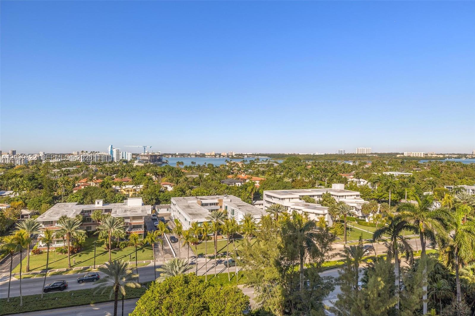 An elevated outdoor view shows a suburban neighborhood with palm trees, apartment buildings, and water — 10175 Collins Ave # 907, Bal Harbour FL 33154, BAL HARBOUR, FL
