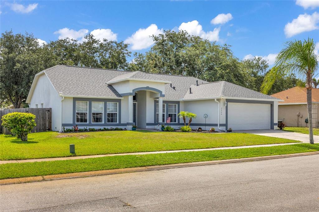 A single-story house with a gray roof, white stucco walls, and a two-car garage — 2400 WOLF CREEK DRIVE, MELBOURNE, FL