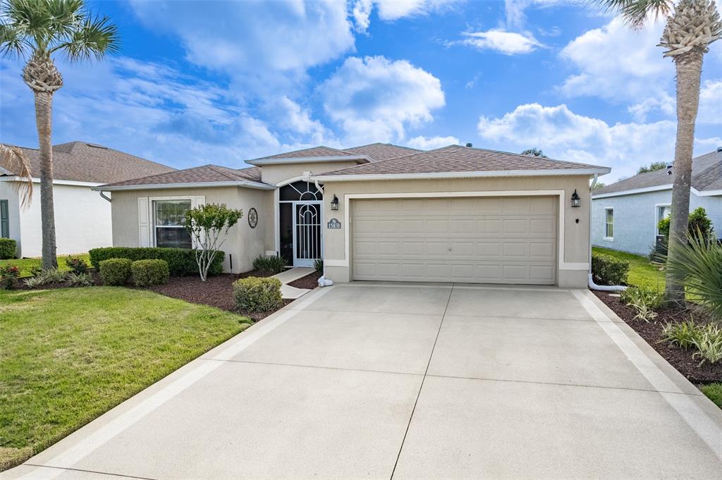 A dark blue front door is framed by a white screen door and sidelights — 15831 SW 16TH AVENUE ROAD, OCALA, FL