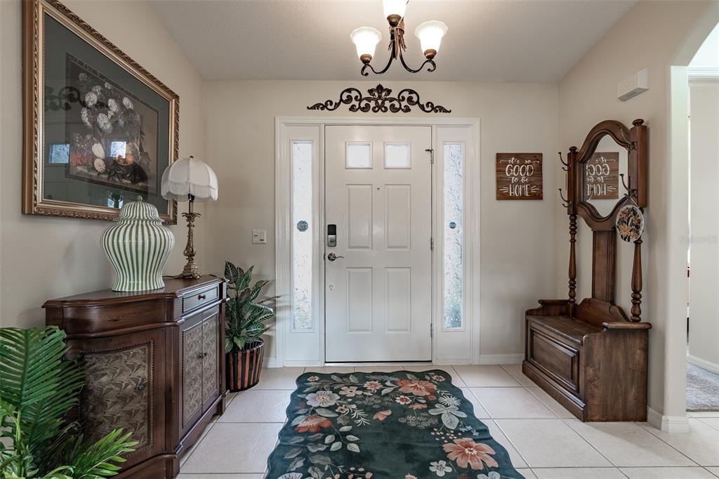 A kitchen features light-colored cabinetry, a breakfast bar with two stools, and tile flooring — 15831 SW 16TH AVENUE ROAD, OCALA, FL