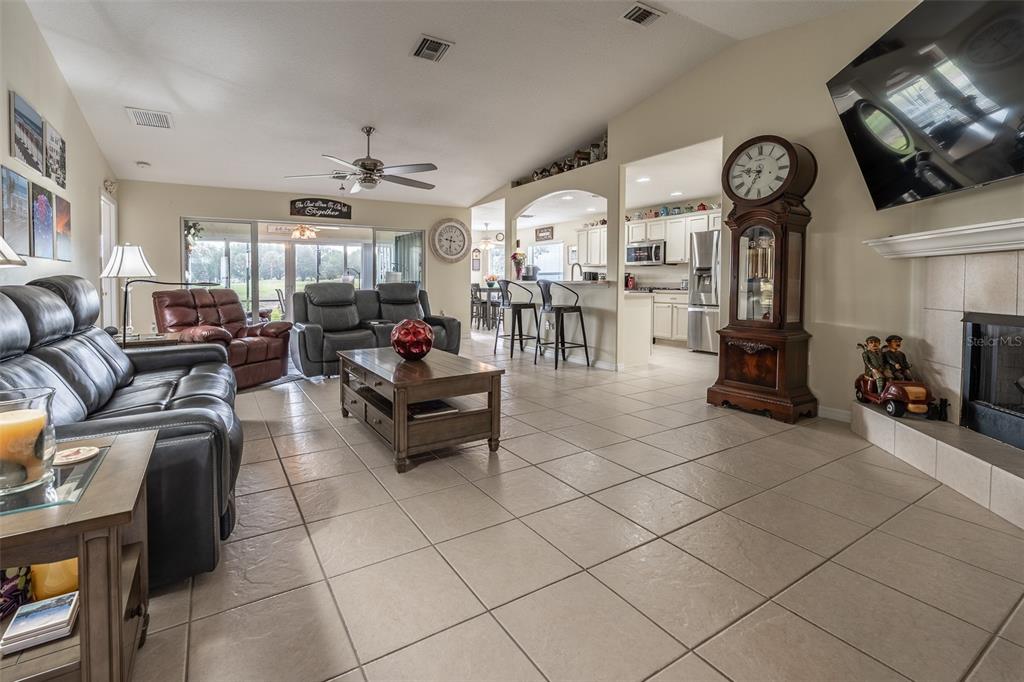 A view from a tiled living room through sliding glass doors to a screened patio — 15831 SW 16TH AVENUE ROAD, OCALA, FL