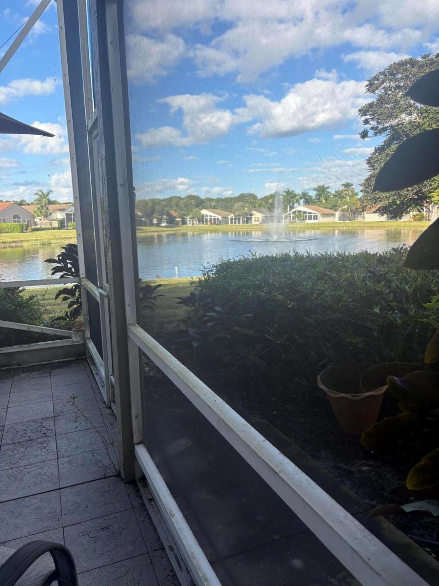 A view of a lake with a fountain from a screened-in patio — 9815 Lemonwood Drive, Boynton Beach FL 33437, BOYNTON BEACH, FL