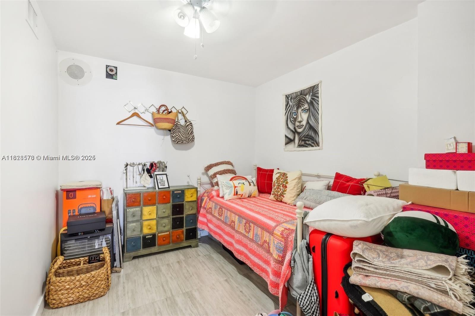A bedroom features a daybed, a colorful multi-drawer chest, and various storage items — 2401 Collins Ave # 1011, Miami Beach FL 33140, MIAMI BEACH, FL