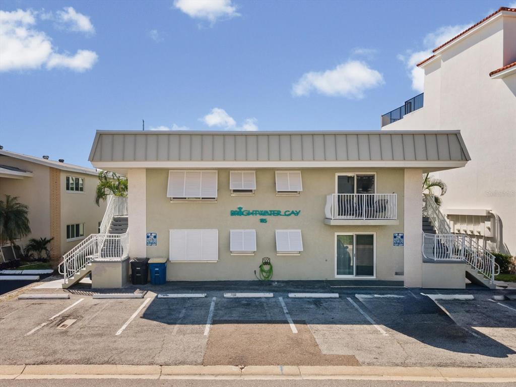 A two-story apartment building exterior features a parking lot, exterior staircases, and a balcony — 185 BRIGHTWATER DRIVE UNIT 5, CLEARWATER BEACH, FL