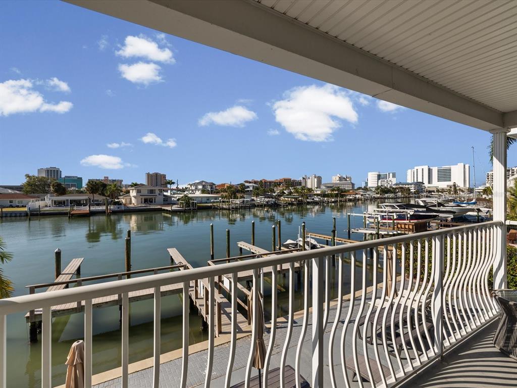 A balcony with a white metal railing overlooks a canal lined with docks and boats — 185 BRIGHTWATER DRIVE UNIT 5, CLEARWATER BEACH, FL
