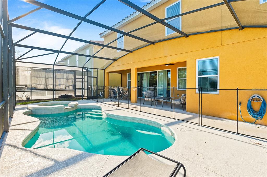 A screened-in patio features a swimming pool, a hot tub, and a yellow exterior wall — 4445 SHIVA LOOP, KISSIMMEE, FL
