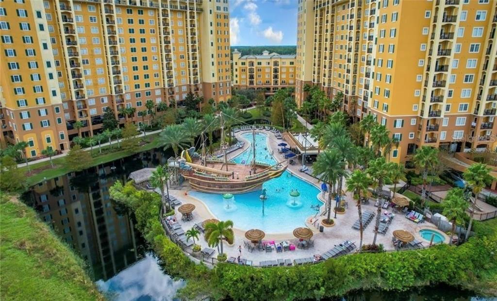 An aerial view shows a resort swimming pool with a large pirate ship play structure — 8100 POINCIANA BOULEVARD UNIT 2203, ORLANDO, FL