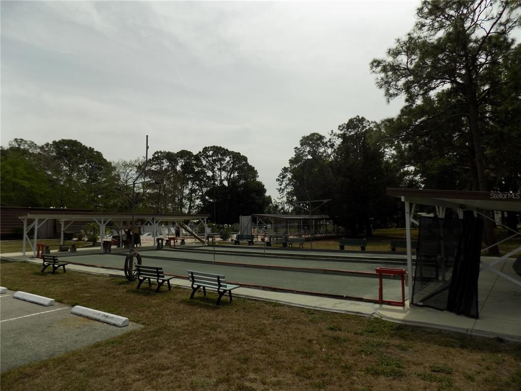 An outdoor shuffleboard court is situated under a covered pavilion near a parking area — 5100 PALENA BOULEVARD, NORTH PORT, FL