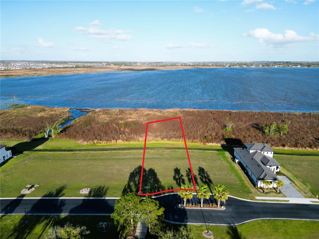 An aerial view shows a vacant residential lot outlined in red bordering a large lake — 344 CALADIUM AVENUE, LAKE ALFRED, FL