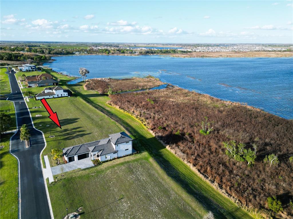 An aerial view shows a house on a large lot next to a lake — 344 CALADIUM AVENUE, LAKE ALFRED, FL