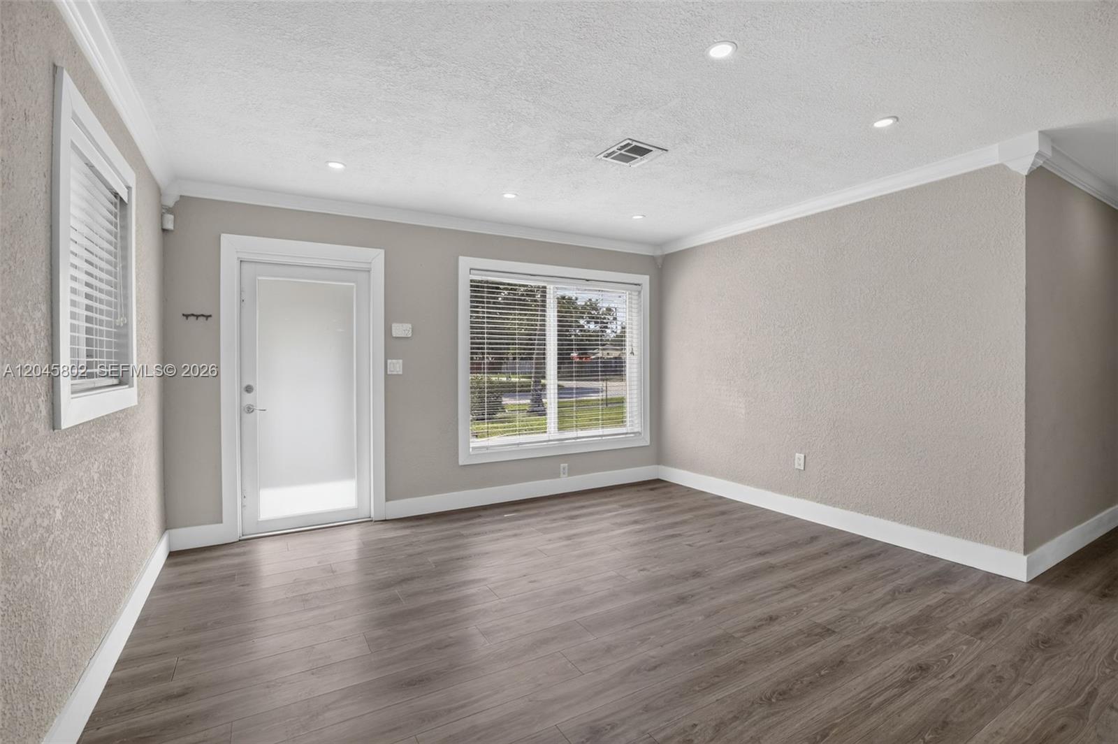 A concrete driveway leads to a small, single-story stucco building with two glass-paneled doors — 1300 N 70th Ter, Hollywood FL 33024, HOLLYWOOD, FL