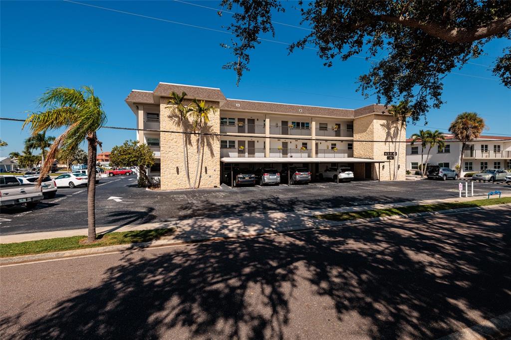 A three-story apartment building with a covered parking area and stone facade exterior — 3789 46TH AVENUE S UNIT 101, ST PETERSBURG, FL
